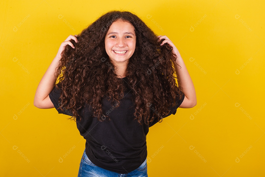 Linda mulher cabelo cacheado jovem sobre fundo isolado amarelo