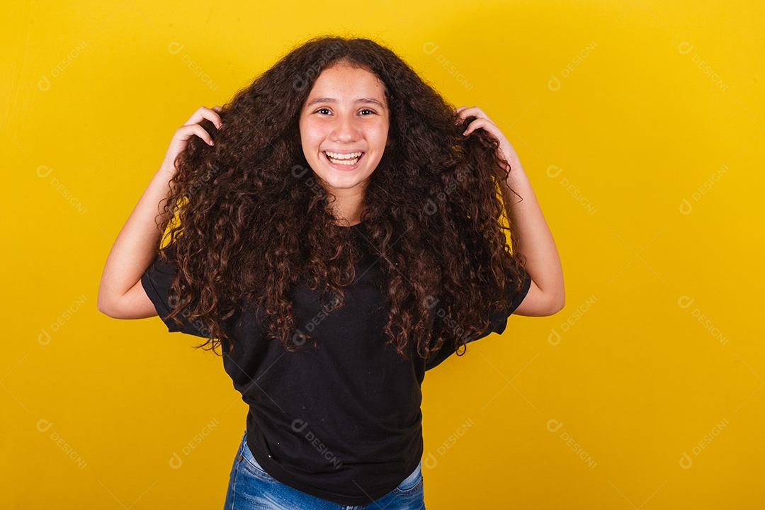 Linda mulher cabelo cacheado jovem sobre fundo isolado amarelo
