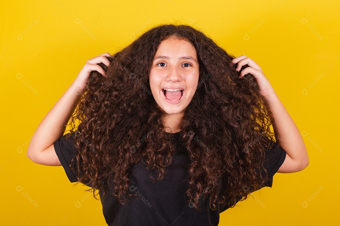 Linda mulher cabelo cacheado jovem sobre fundo isolado amarelo