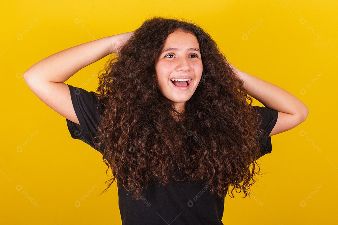 Linda mulher cabelo cacheado jovem sobre fundo isolado amarelo