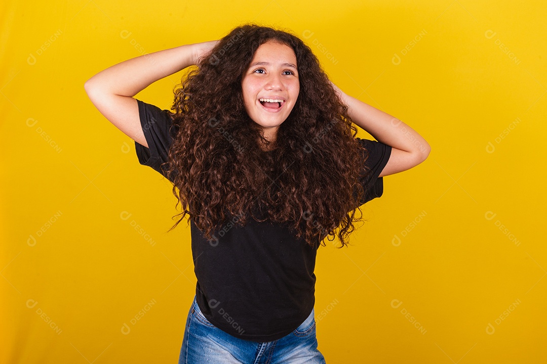 Linda mulher cabelo cacheado jovem sobre fundo isolado amarelo