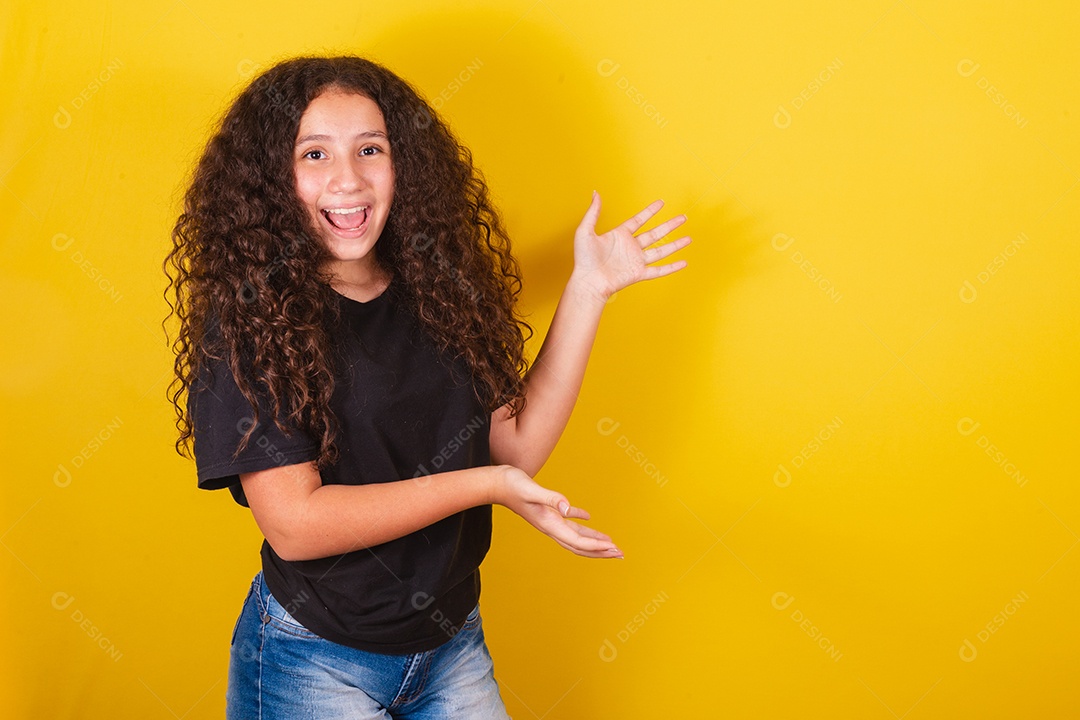 Linda mulher cabelo cacheado jovem sobre fundo isolado amarelo