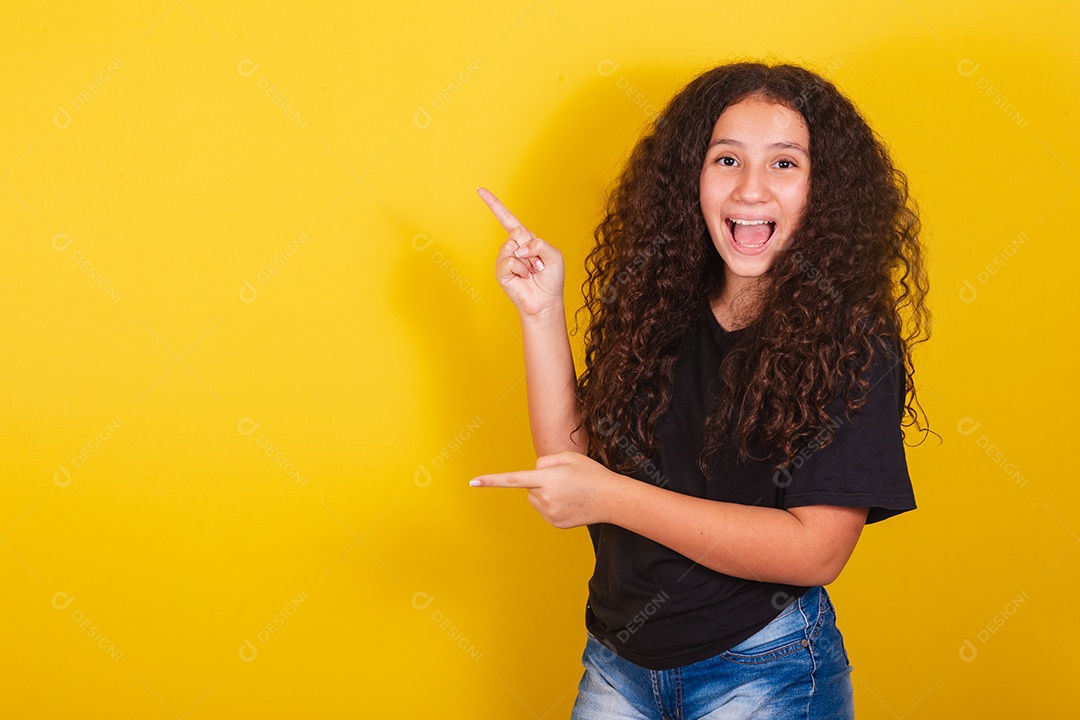 Linda mulher cabelo cacheado jovem sobre fundo isolado amarelo