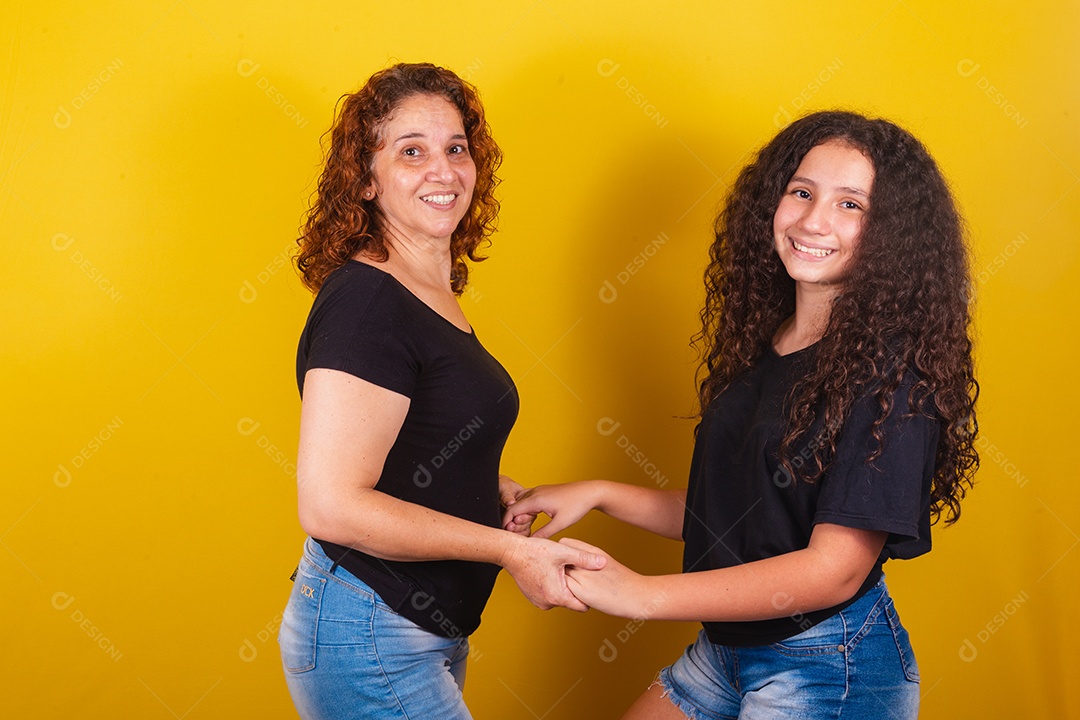 Avó ao lado de usa neta lindas mulheres felizes sobre fundo amarelo