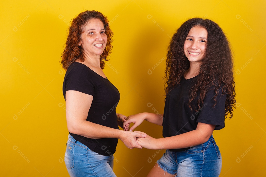 Avó ao lado de usa neta lindas mulheres felizes sobre fundo amarelo