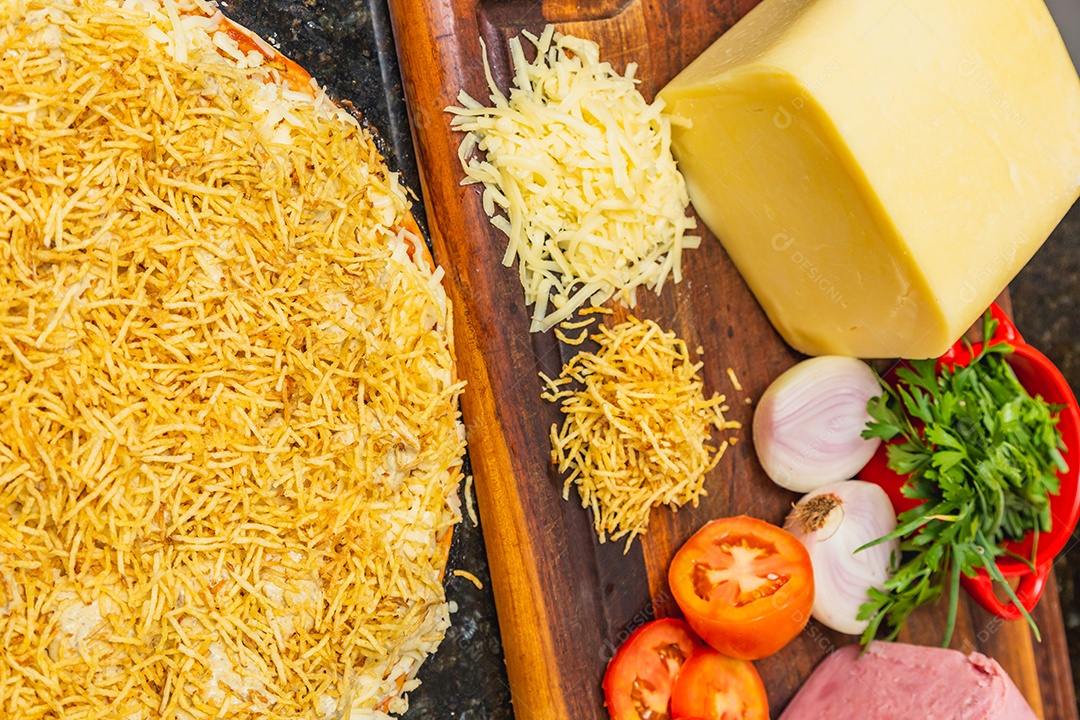 Preparação de deliciosa pizza de strogonoff, feita com carne, queijo e batata frita