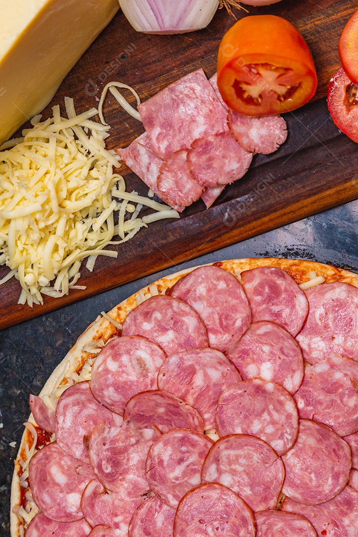 Preparação de pizza, espalhando rodelas de pepperoni e fatias na pizza