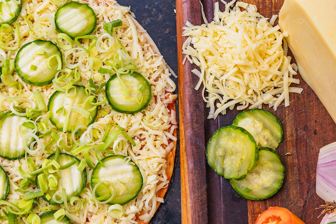 Preparação de pizza, espalhando fatias de pepino e fatias em vegetais