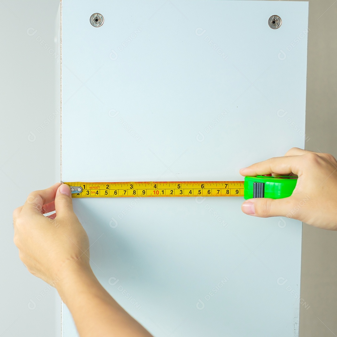 Mão de homem usando fita métrica para medir móveis em casa. faça você mesmo