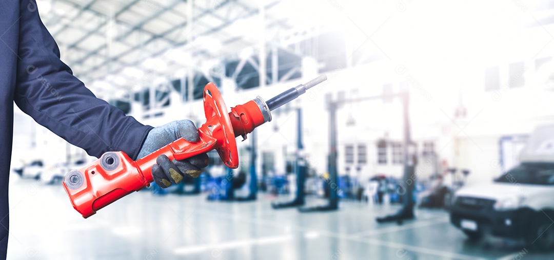 Mão do mecânico que guarda um amortecedor dianteiro do carro