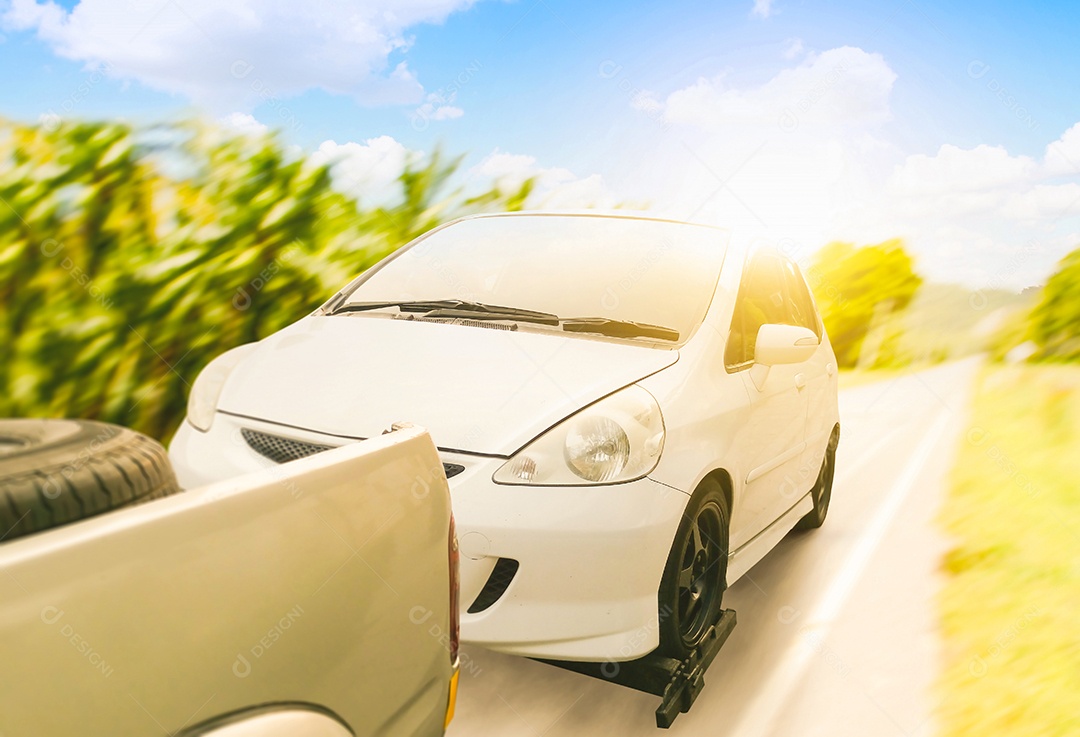 O carro quebrado é rebocado por um veículo de reboque na estrada