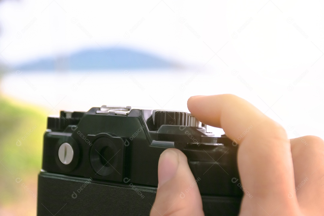 Um turista pressiona o obturador de uma câmera de filme para capturar uma foto