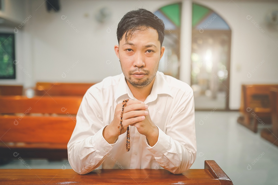 Barba de homem asiático vestindo com camisa christian orando
