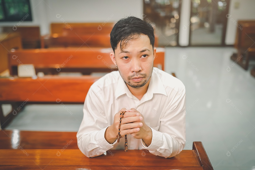 Barba de homem asiático vestindo com camisa christian orando
