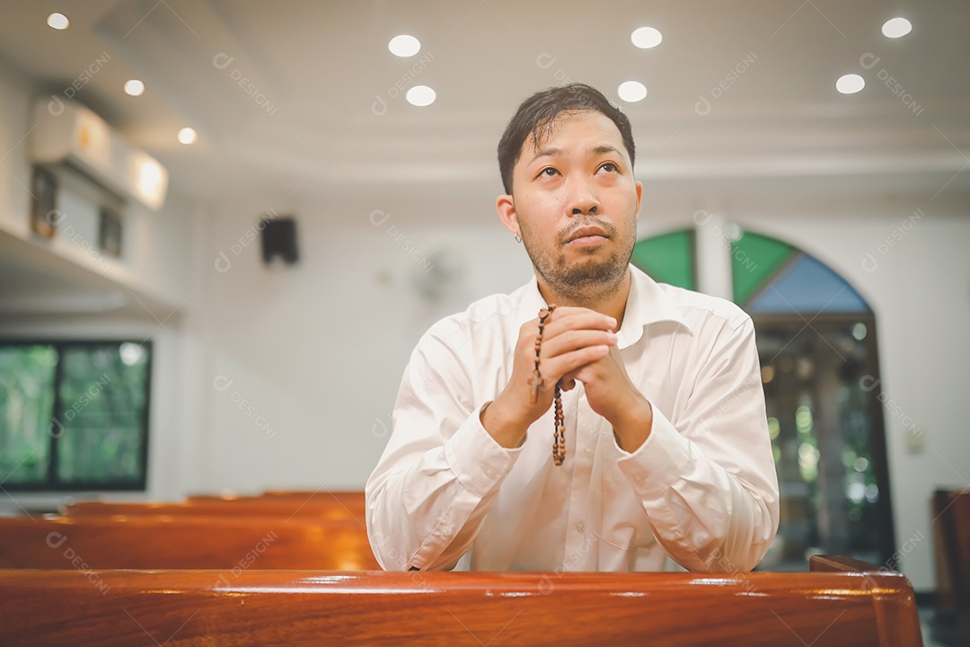 Barba de homem asiático vestindo com camisa christian orando