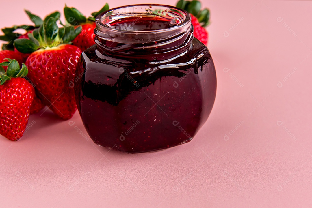 Geleia de morango em fundo rosa com morangos