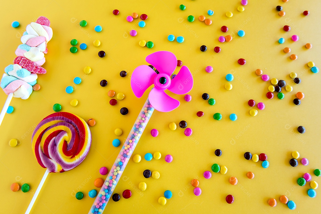 dia das crianças, pirulitos e chocolates em fundo amarelo