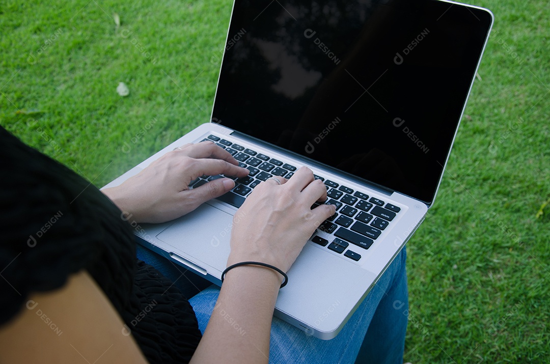 Mulher com as mãos em um laptop.