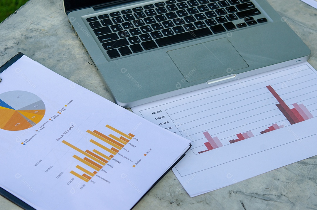 Negócios gráficos de papel financeiro e laptop.