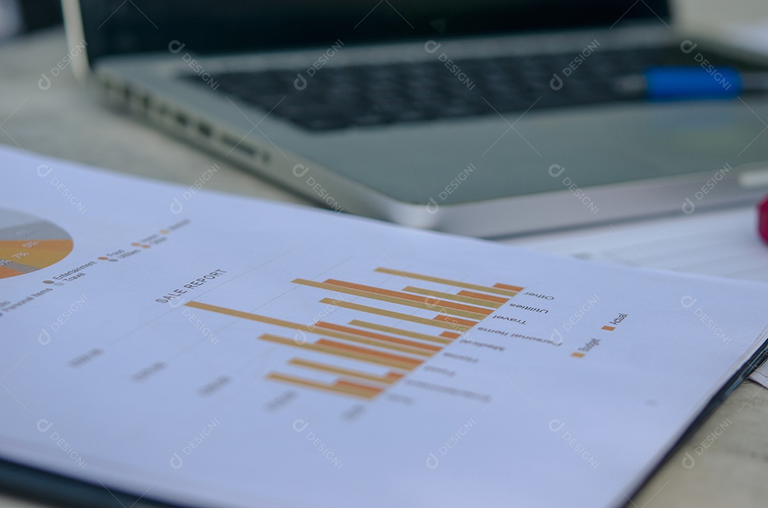 Negócios gráficos de papel financeiro e laptop.