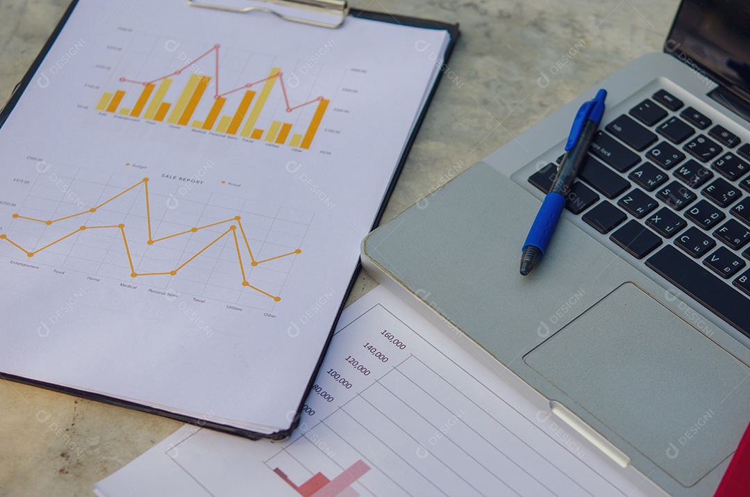 Negócios gráficos de papel financeiro e laptop.