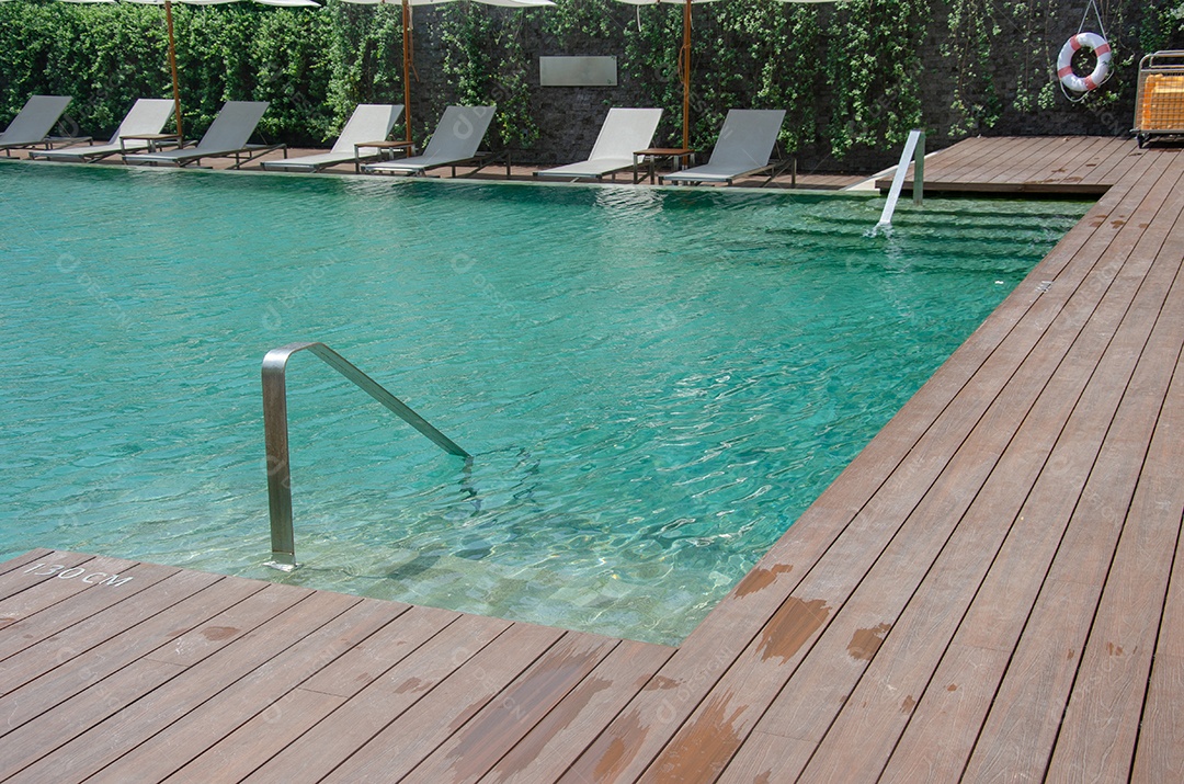 Cadeiras de luxo bonitas à beira da piscina no hotel.