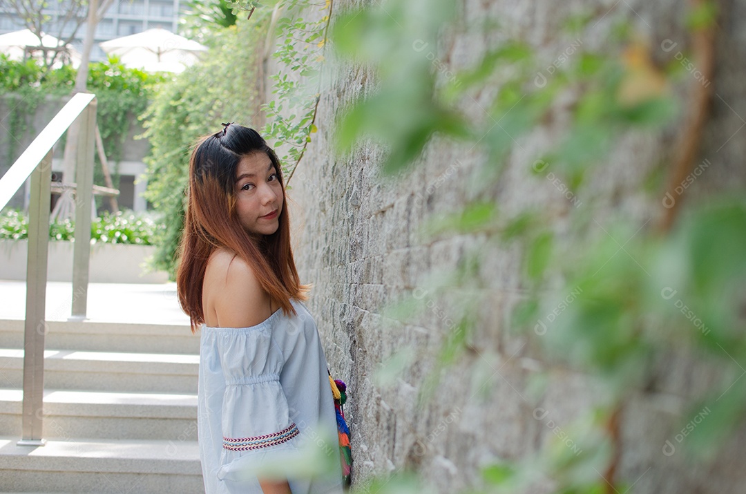 Linda mulher asiática nas paredes cinzentas.