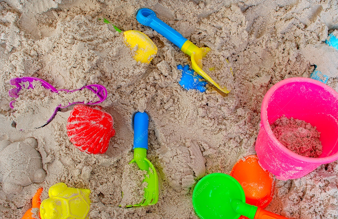 Brinquedos infantis na praia de areia.