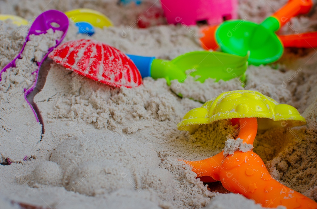 Brinquedos infantis na praia de areia.