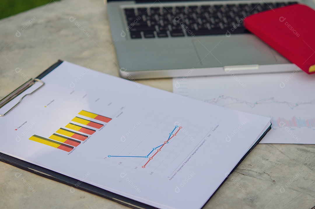Negócios gráficos de papel financeiro e laptop.