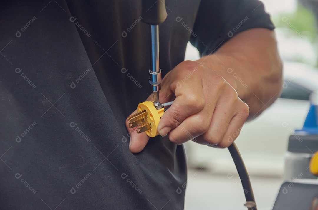 Homens reparando um soquete com uma chave de fenda.