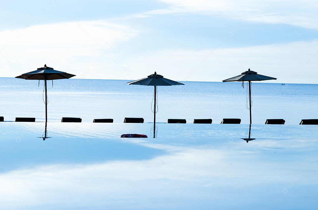 Piscina de guarda-sóis e o mar.