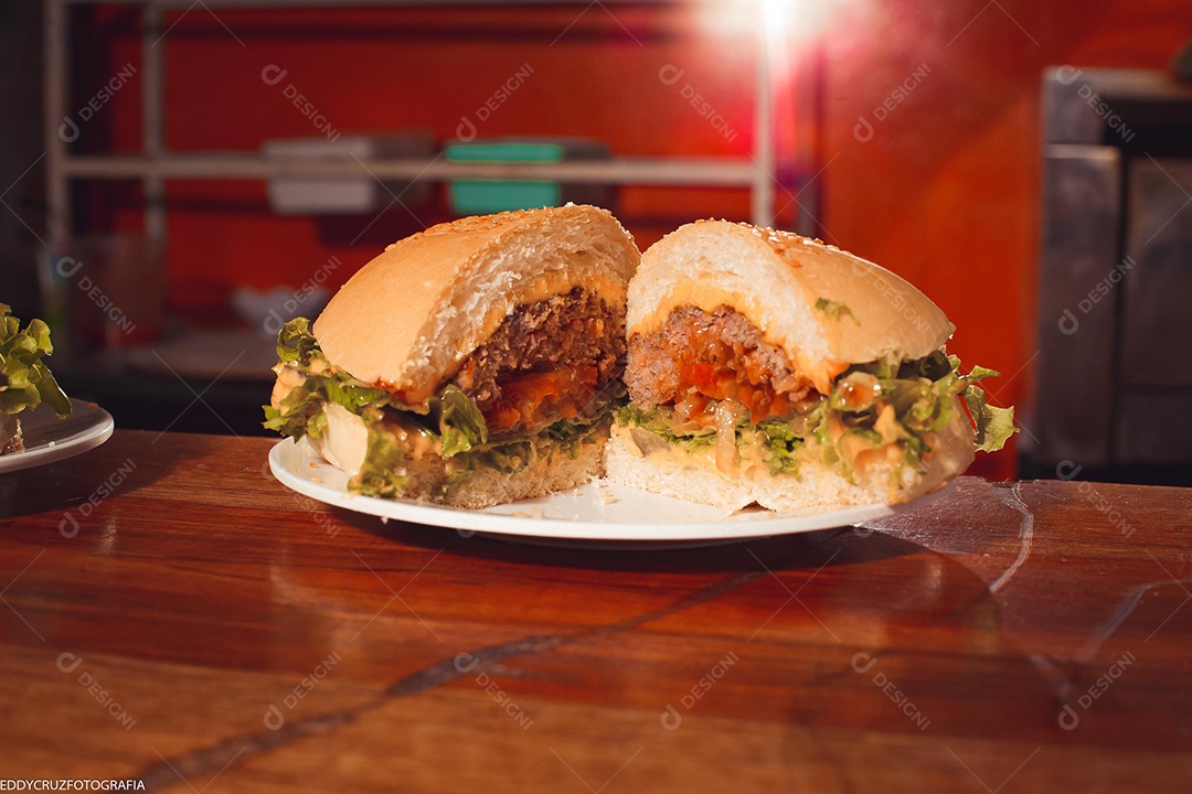 Hamburger being served on a white plate.