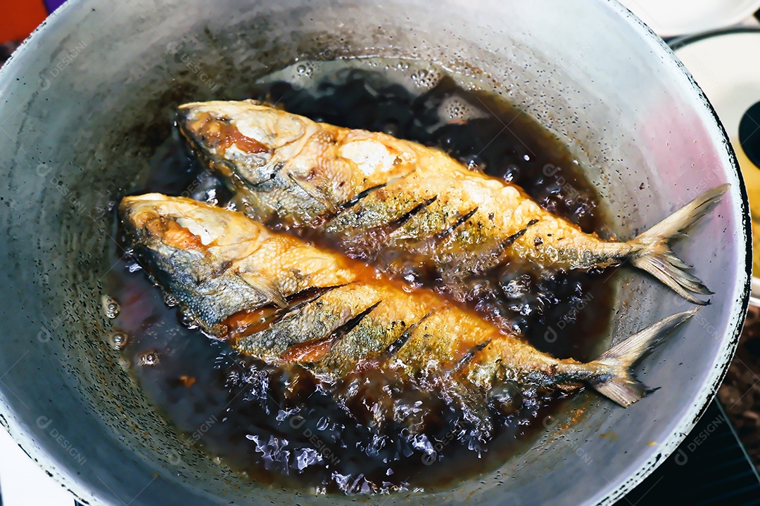 Frite de peixe salgado em uma panela com óleo de cozinha, conce de comida de estilo tailandês