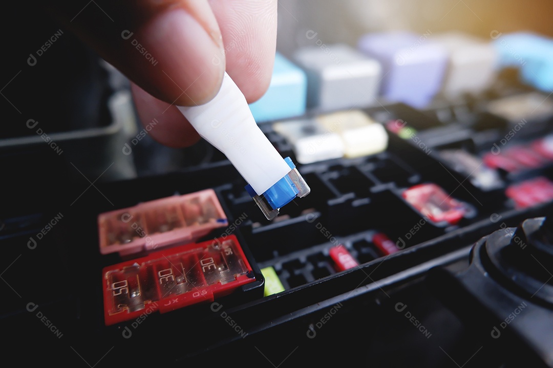 O mecânico substitui o fusível sobressalente na caixa de fusíveis do carro