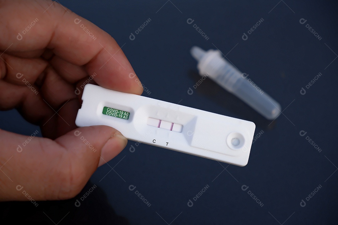 A mão humana exibe um cassete de resultado positivo Covid-19