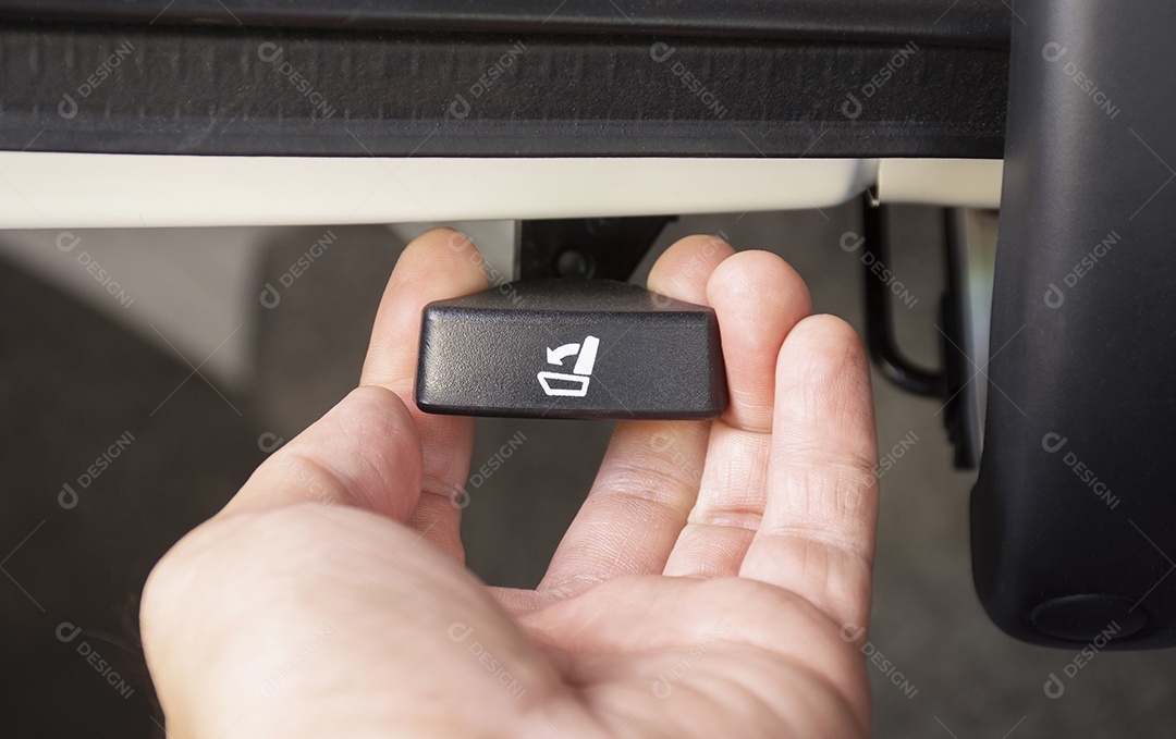 A mão do motorista está puxando o botão de rebatimento do segundo assento do carro