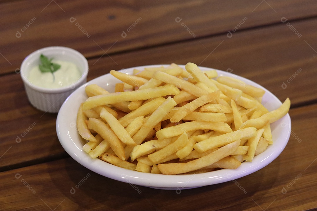 Prato de batata frita servido sobre mesa de mesa de madeira