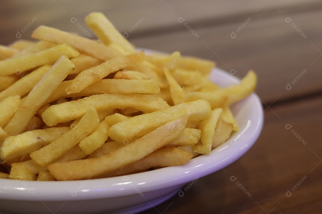 Prato de batata frita servido sobre mesa de mesa de madeira