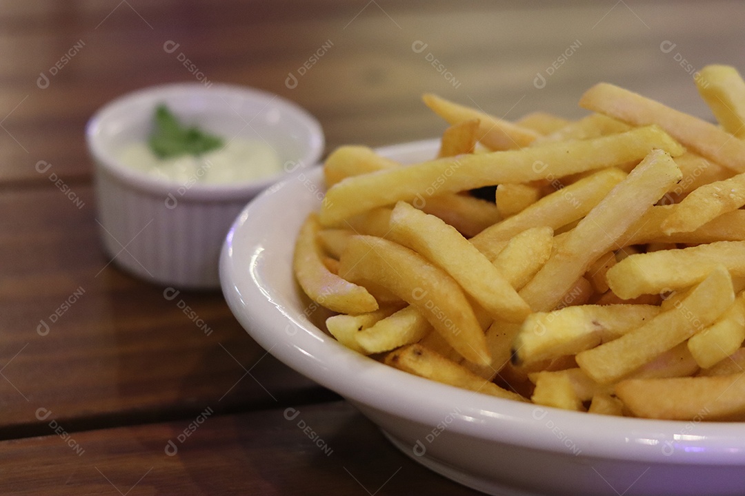 Prato de batata frita servido sobre mesa de mesa de madeira