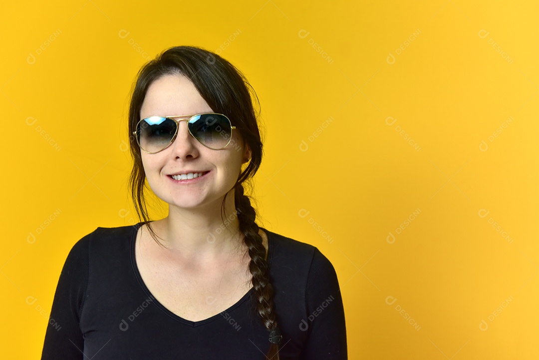 Linda garota de óculos escuros em fundo amarelo.