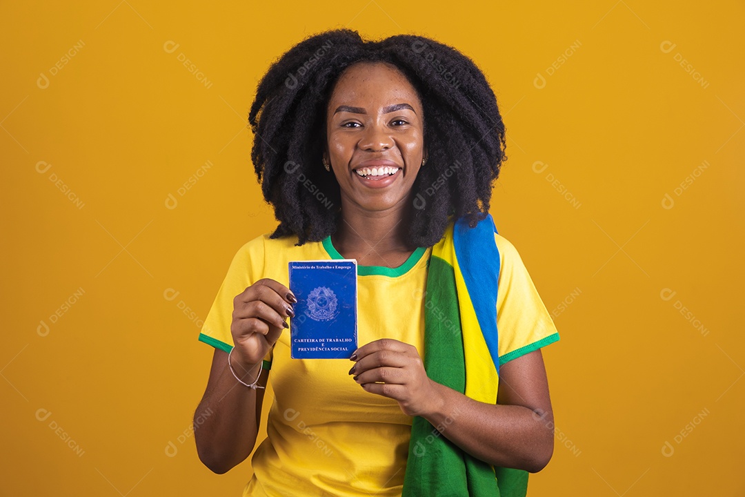 Mulher afro-brasileira vestindo camiseta do Brasil segurando uma carteira de trabalho