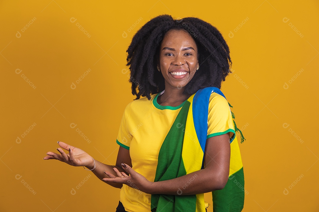 Mulher afro-brasileira vestindo camiseta do Brasil fazendo gestos