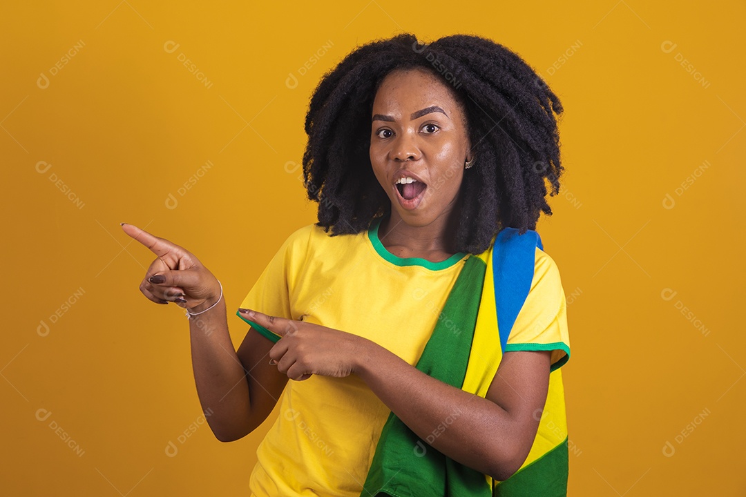 Mulher afro-brasileira vestindo camiseta do Brasil fazendo gestos
