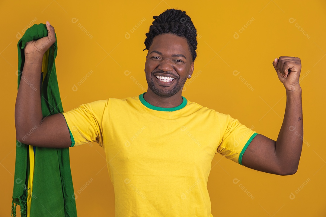 Homem brasileiro vestindo uma camiseta do Brasil segurando acessórios de torcida