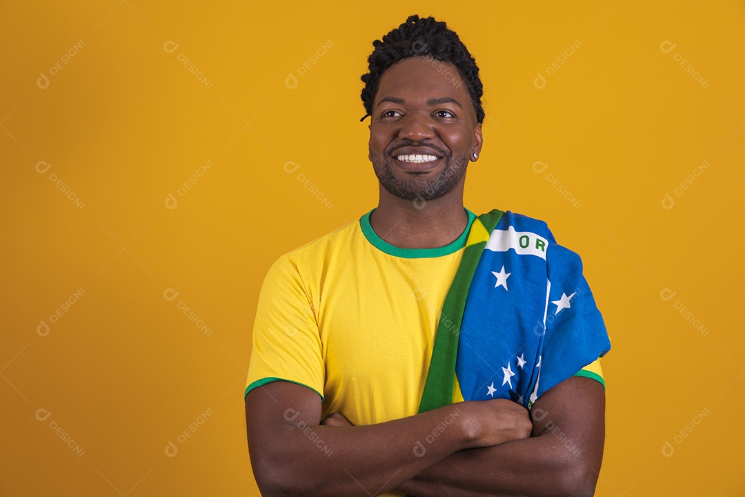 Homem brasileiro vestindo uma camiseta do Brasil segurando acessórios de torcida