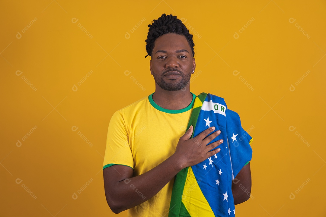 Homem brasileiro vestindo uma camiseta do Brasil segurando acessórios de torcida