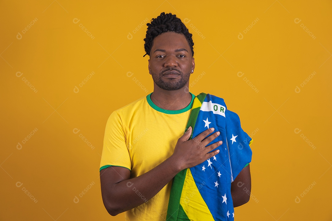 Homem brasileiro vestindo uma camiseta do Brasil segurando acessórios de torcida
