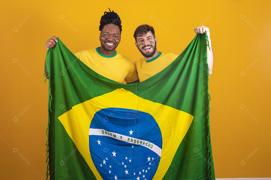 Homens brasileiros vestidos com camisetas do Brasil segurando acessórios de torcidas