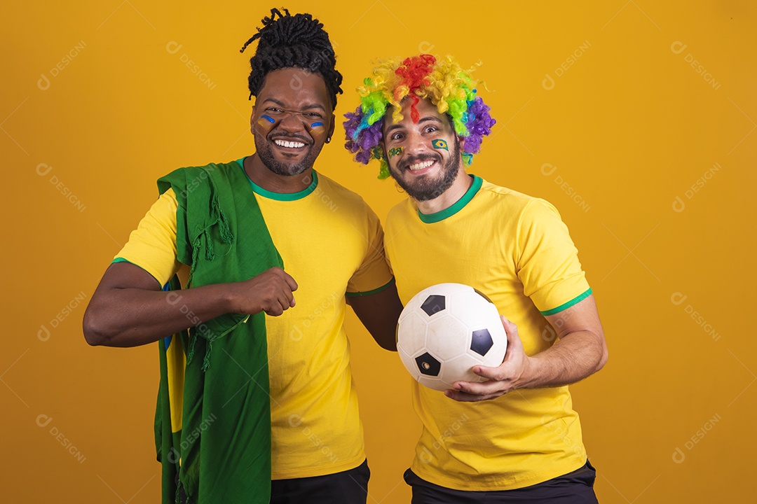 Homens brasileiros vestidos com camisetas do Brasil segurando acessórios de torcidas